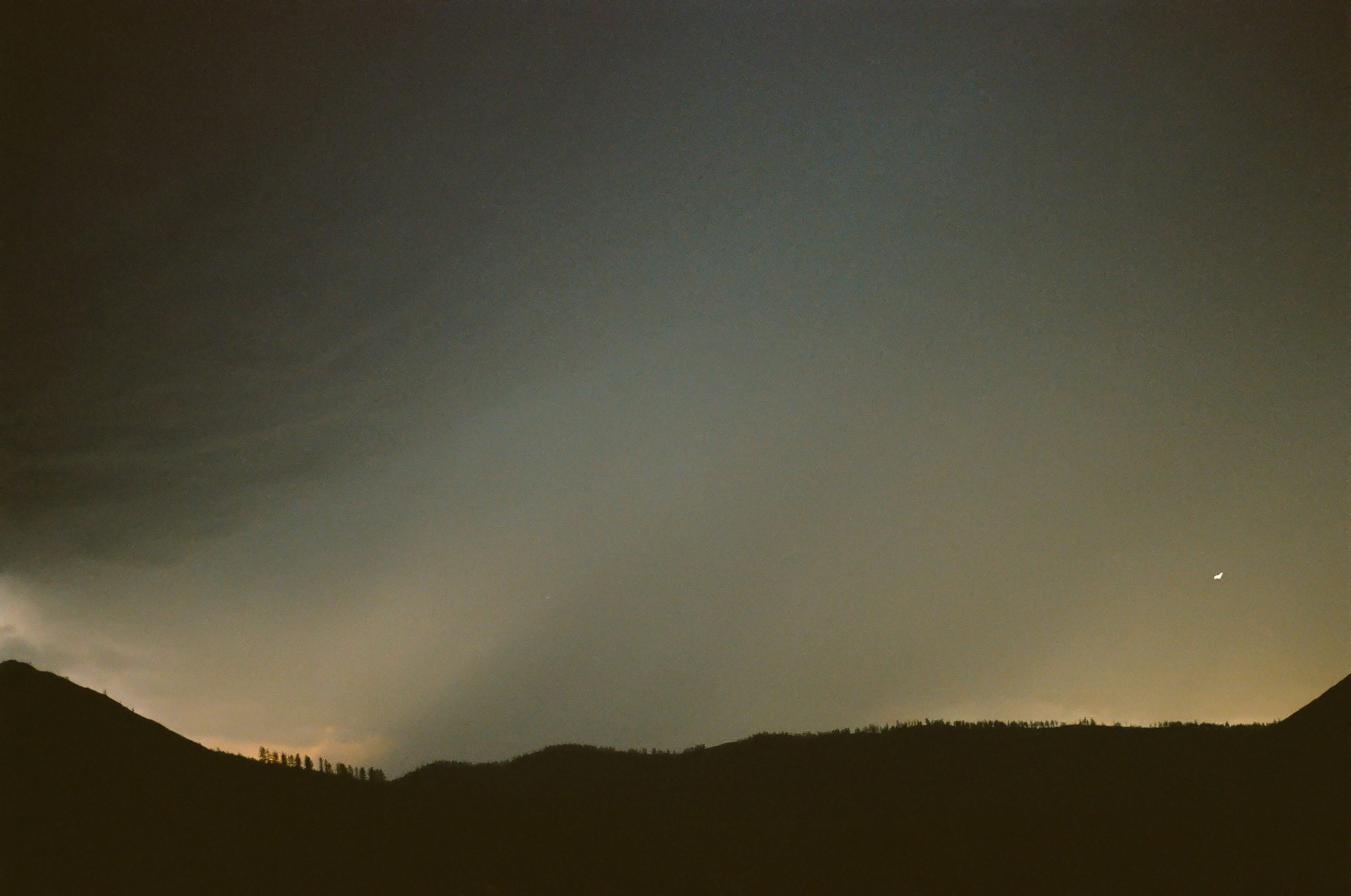 A dark rigid line overheard is highlighted by storm clouds, nearly yellow with an ominent energy. The air looks electric.