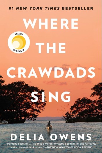 The book cover of "Where the Crawdads Sing" with a woman paddling in a marsh under a pale salmon sky.