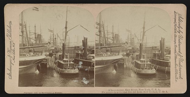 : A stereograph featuring two docked tugboats side by side, dwarfed by a larger vessel that extends out of the frame.