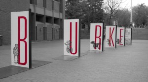 a sign for the burke museum that spells out 'burke' in five separate panels. Each panel has one letter and there is space between each panel.