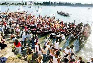 Countless people gather around and in canoes arriving at the Tulalip reservation.