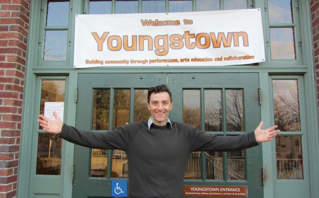 Man standing in front of a door way, arms open