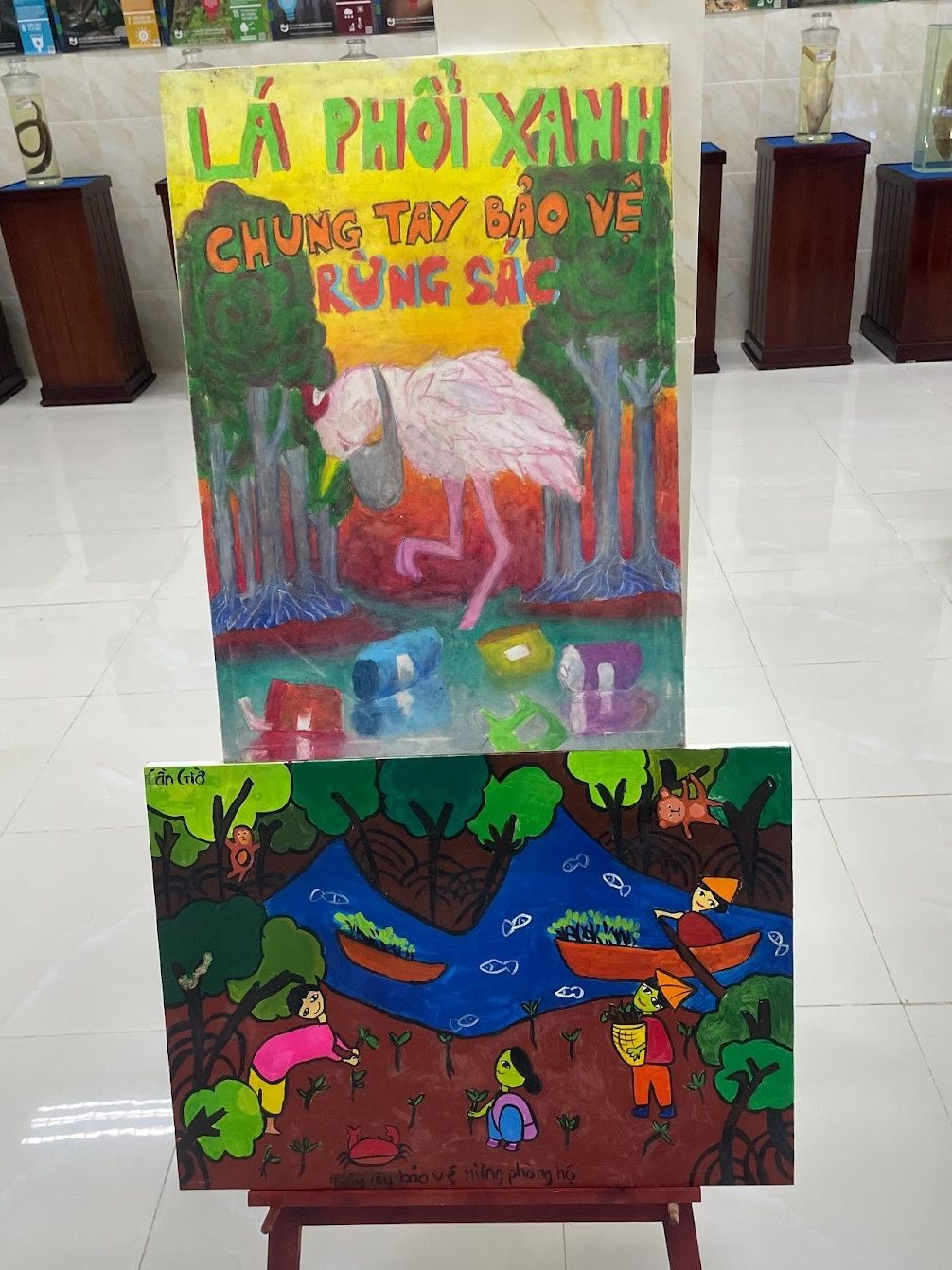 Alt text: Children’s paintings displayed at the Center for Environmental Education and Ecotourism in Cần Giờ titled “The green lungs: let’s join hands to protect the Rừng Sác”
