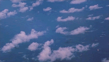 Alt text: GIF depicts an atomic bomb mushroom cloud formation above Bikini Atoll and the surrounding ocean.